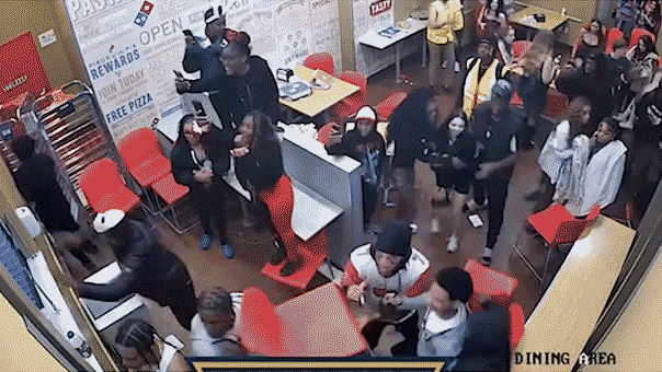 Violent brawl erupts in Domino’s as suspects hurl chair, strike officer's head gif of rowdy crowd causing a fight inside a domino's pizza