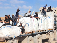 Hamas terrorists carrying clubs and firearms secure, and divert humanitarian aid trucks in the northern Gaza area of Jabaliya on June. 25