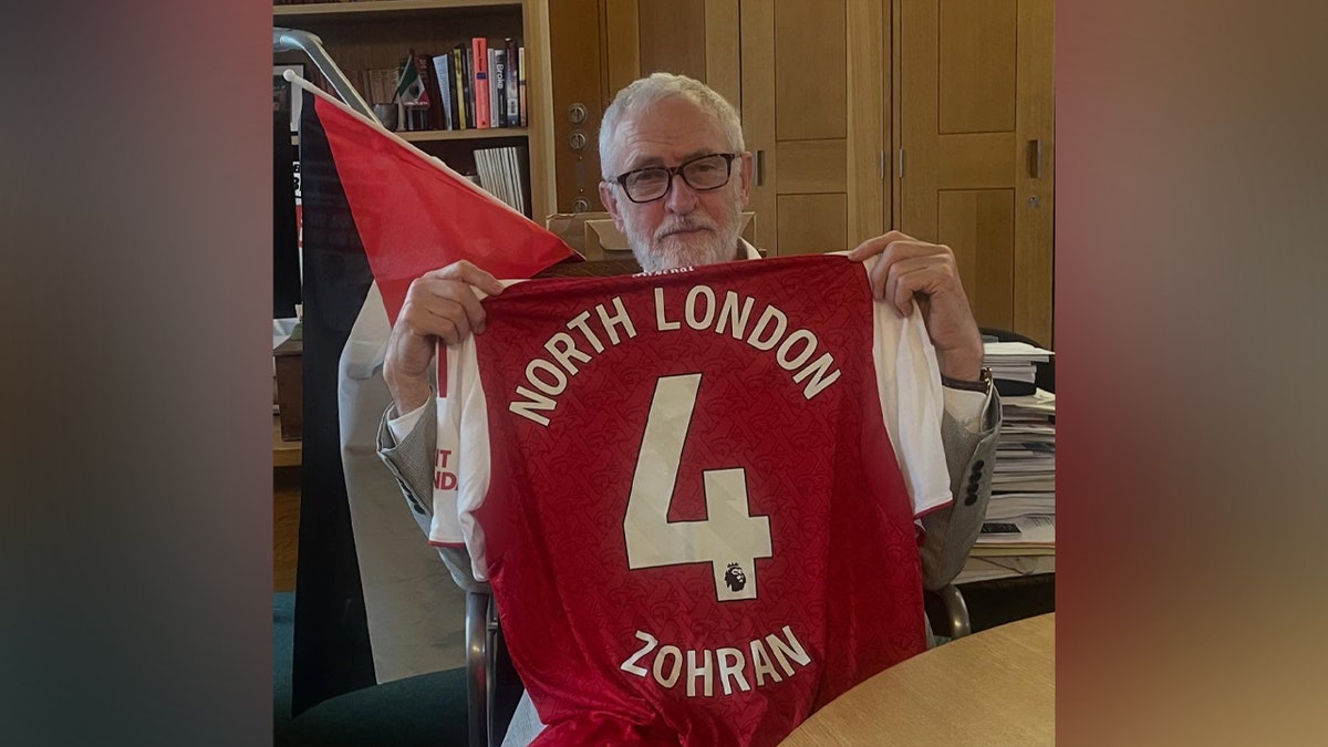 UK politician Jeremy Corbyn, who was ousted over antisemitism allegations, shows support for Zohran Mamdani Jeremy Corbyn holding up a jersey.