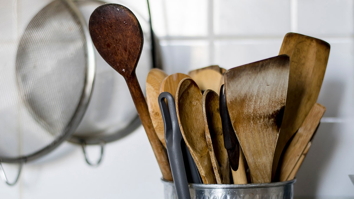 Old wooden kitchen utensils in a metal bowl
