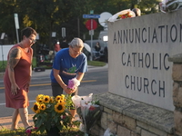 Mourners visit a memorial set up for victims of the mass school shooting at a Catholic school church.